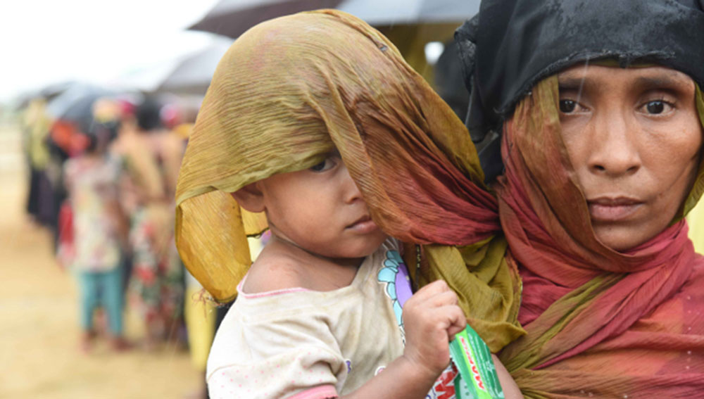 Rohingya refugees queue up in the rain to receive relief supplies near the Leda camp in Teknaf, southeastern Bangladesh, Sept. 27, 2017. Photo: Abdur Rahman/BenarNews 