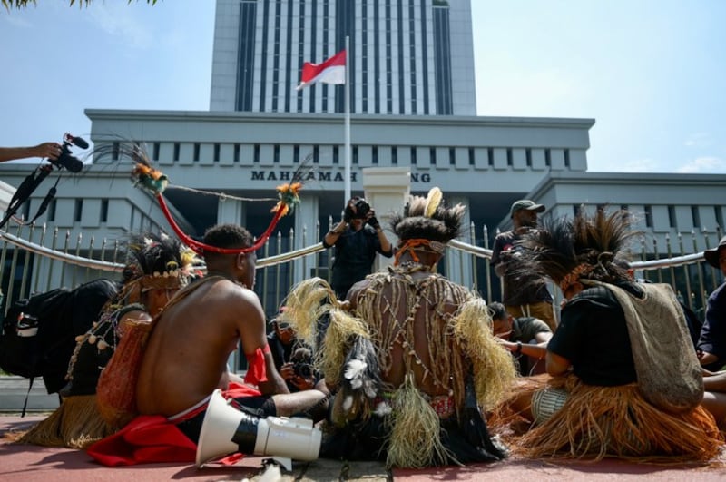 Anggota suku asli Awyu dan Moi di Papua melakukan protes di depan Mahkamah Agung di Jakarta mendesak agar izin operasi perusahaan kelapa sawit di tanah Papua dicabut, 27 Mei 2024. [Bay Ismoyo/AFP]