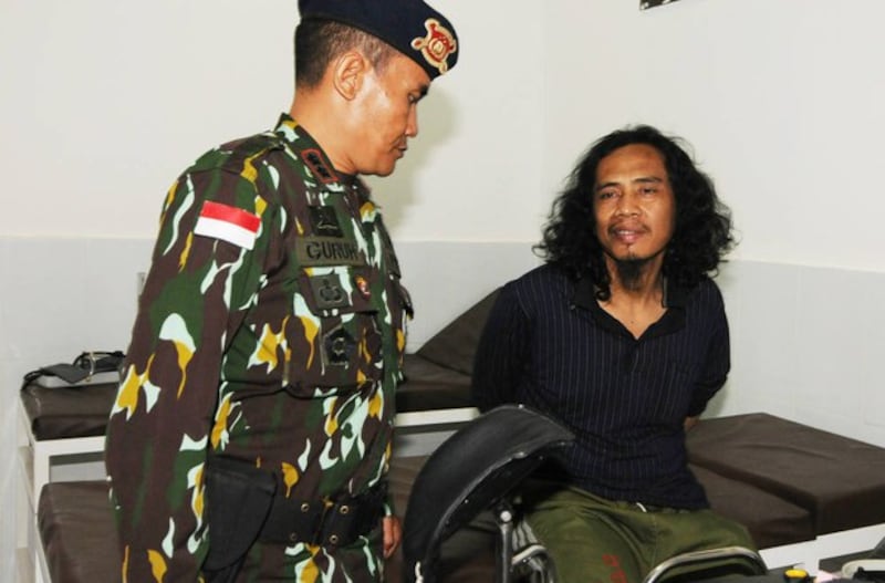 Seorang polisi menjaga tersangka militan MIT Muhammad Basri (kanan) di sebuah rumah sakit militer di Poso, Sulawesi Tengah14 September 2016. [Keisyah Aprilia/BenarNews]