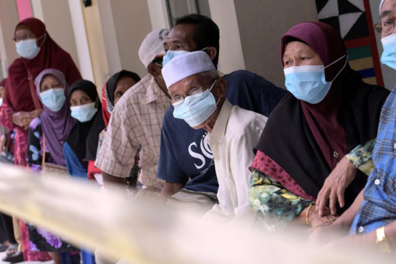 Voters wear masks to help curb the spread of COVID-19 as they wait for their turn to vote in state elections at a polling station near Kota Kinabalu, the capital of Malaysia's Sabah state, Sept. 26, 2020. [AP] 