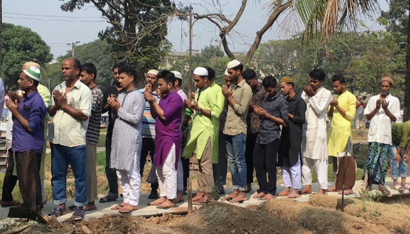 People pray near the graves of victims of the fire in Old Dhaka at the Azimpur Cemetery in Dhaka, Feb. 22, 2019. [Megh Monir/BenarNews] 